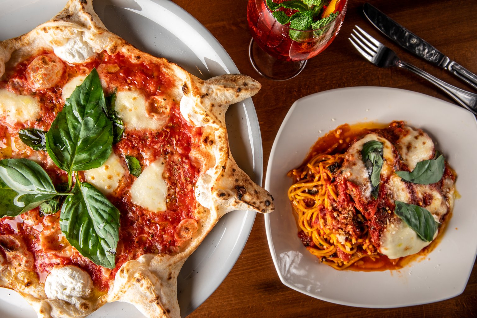 Amalfi pizza and pasta served together with tomato sauce, melted cheese and fresh basil