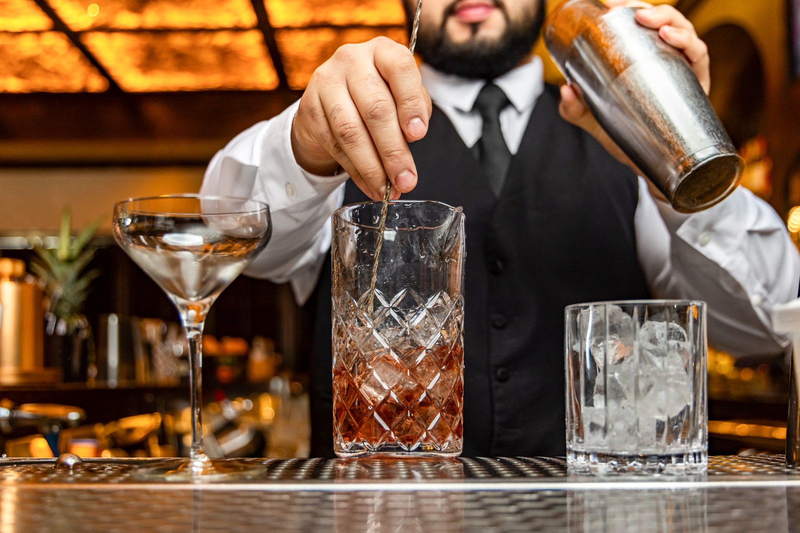 A Red Phone Booth bartender stirring a cocktail in a crystal mixing glass